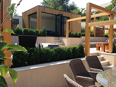 modern chelsea stlye garden with seating and light stone steps and box hedging